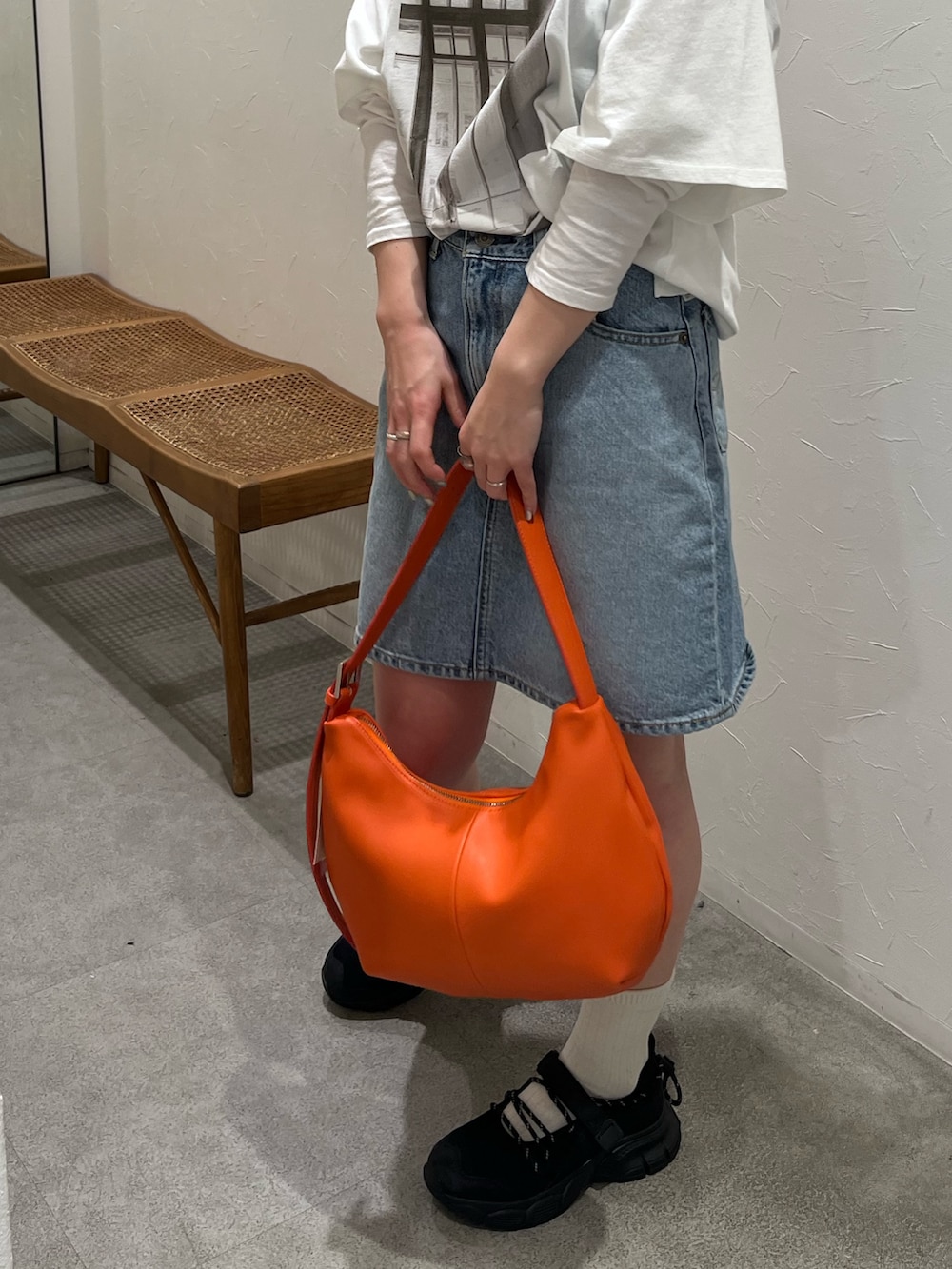 ホワイト系のTシャツ/カットソー、ブルー系のスカート、ブラック系のスニーカーを着用したレディースの春コーディネートの6枚目の写真