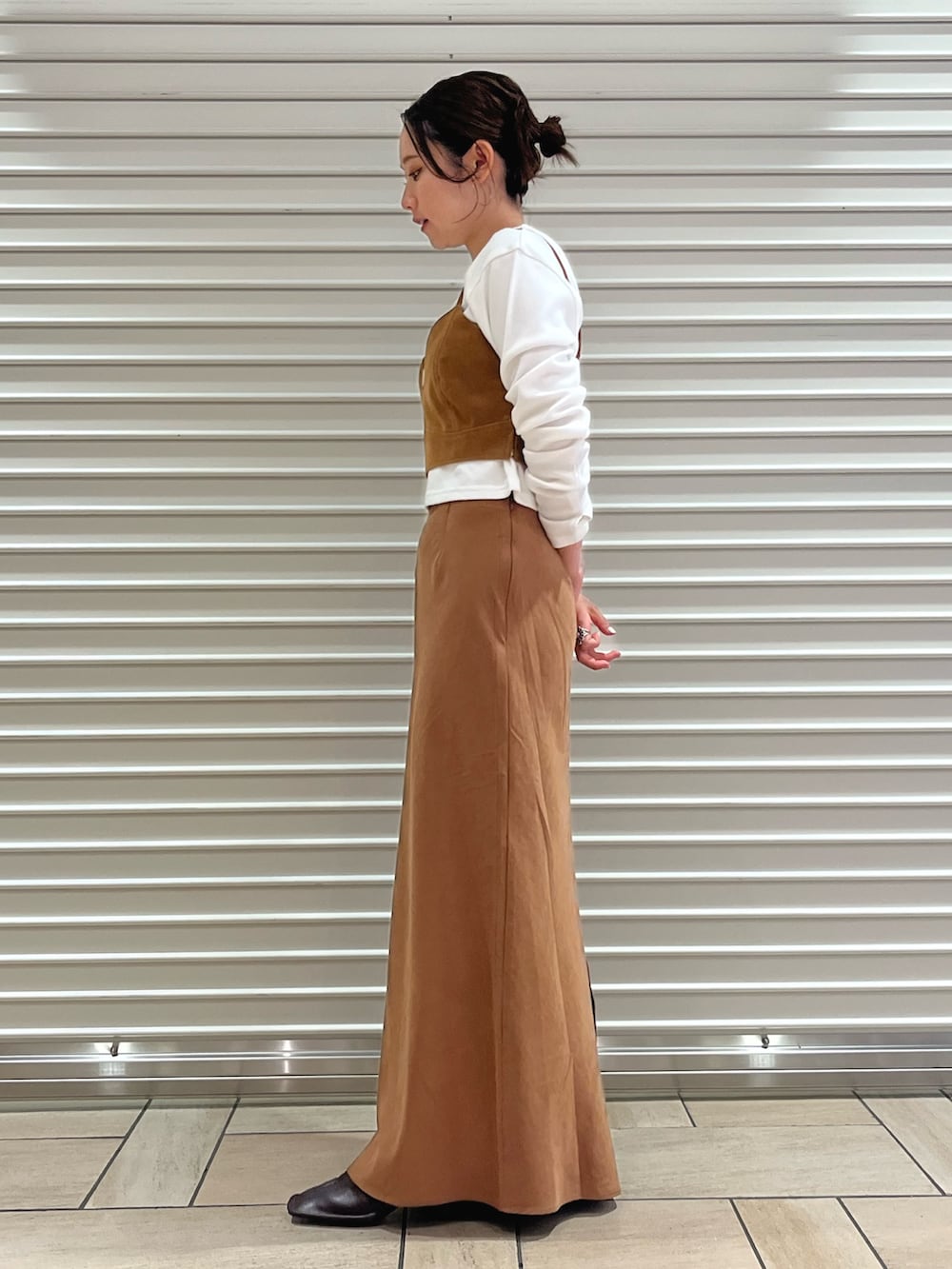 ブラウン系のキャミソール、ブラウン系のスカート、ホワイト系のTシャツ/カットソーを着用したレディースの秋コーディネートの2枚目の写真