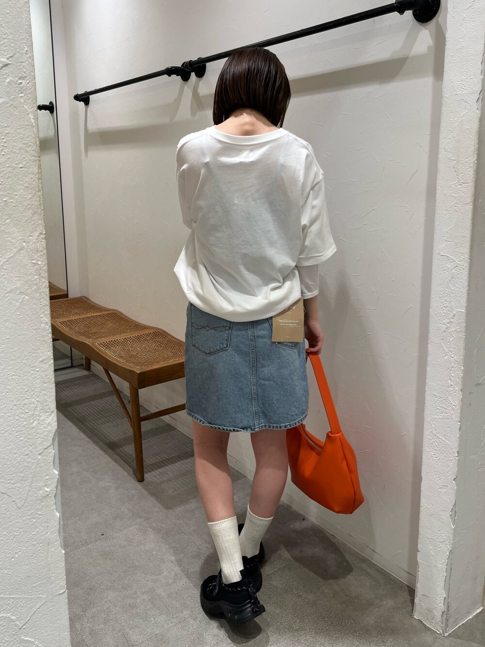 ホワイト系のTシャツ/カットソー、ブルー系のスカート、ブラック系のスニーカーを着用したレディースの春コーディネートの3枚目の写真