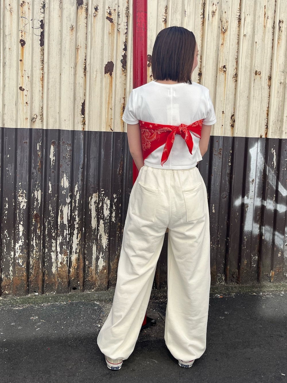 ホワイト系のTシャツ/カットソー、ホワイト系のスウェットパンツ、レッド系のストール/ショールを着用したレディースの春コーディネートの2枚目の写真