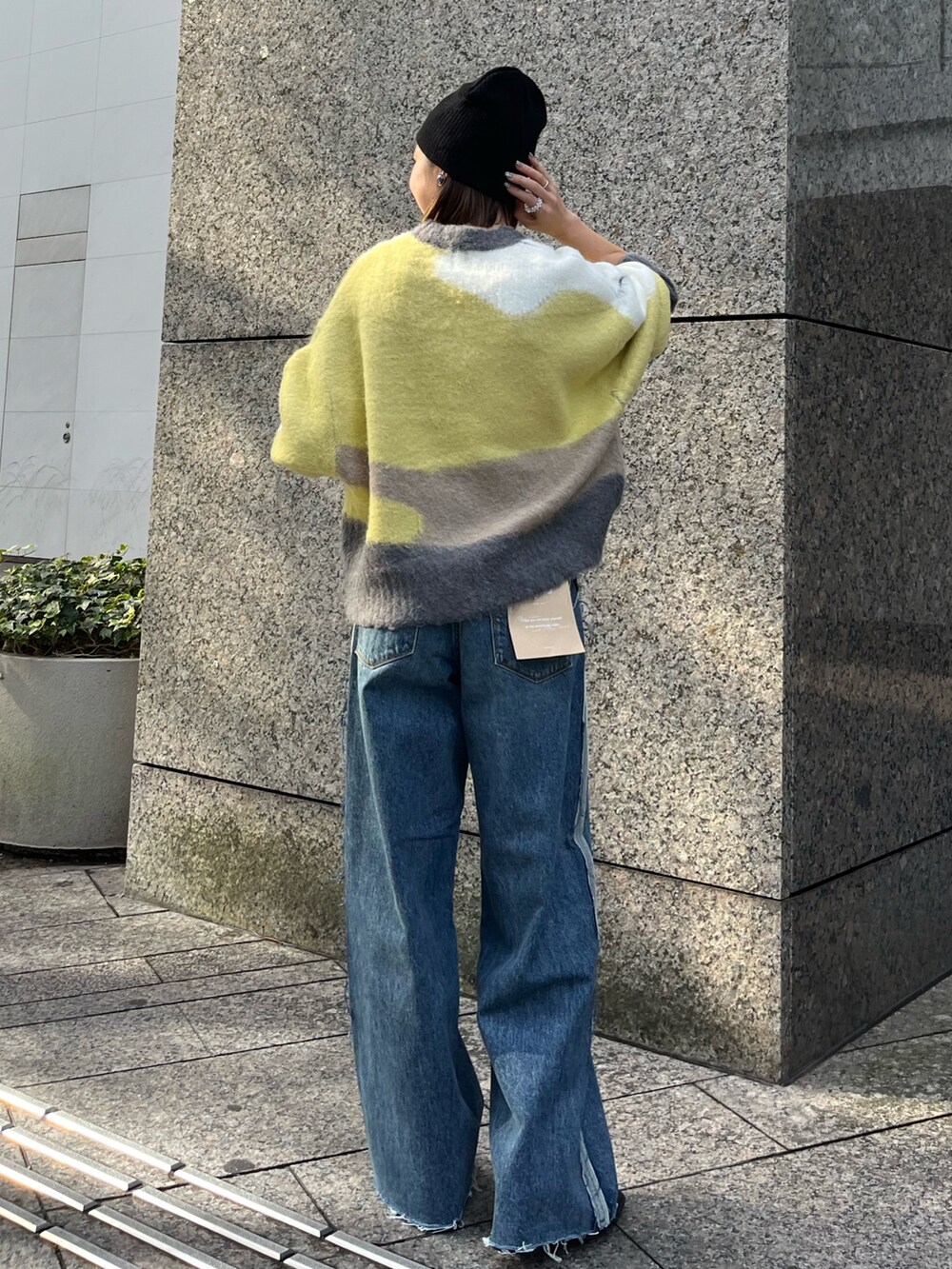 グリーン系のニット/セーター、ブルー系のデニムパンツ、ブラック系のニットキャップ/ビーニーを着用したレディースの秋コーディネートの3枚目の写真