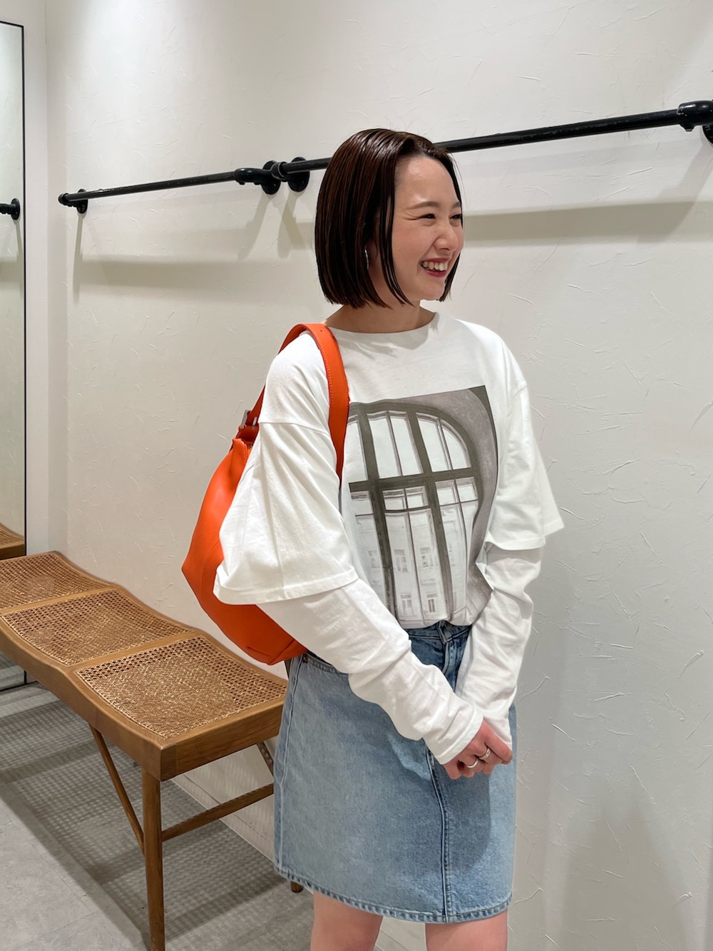ホワイト系のTシャツ/カットソー、ブルー系のスカート、ブラック系のスニーカーを着用したレディースの春コーディネートの4枚目の写真