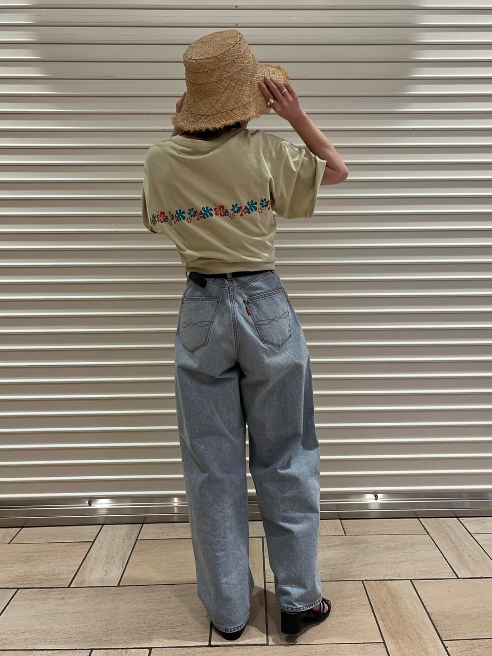ブルー系のデニムパンツ、ベージュ系のTシャツ/カットソー、ベージュ系のハットを着用したレディースの夏コーディネートの3枚目の写真
