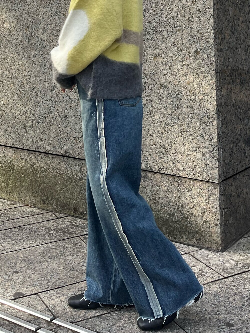 グリーン系のニット/セーター、ブルー系のデニムパンツ、ブラック系のニットキャップ/ビーニーを着用したレディースの秋コーディネートの5枚目の写真