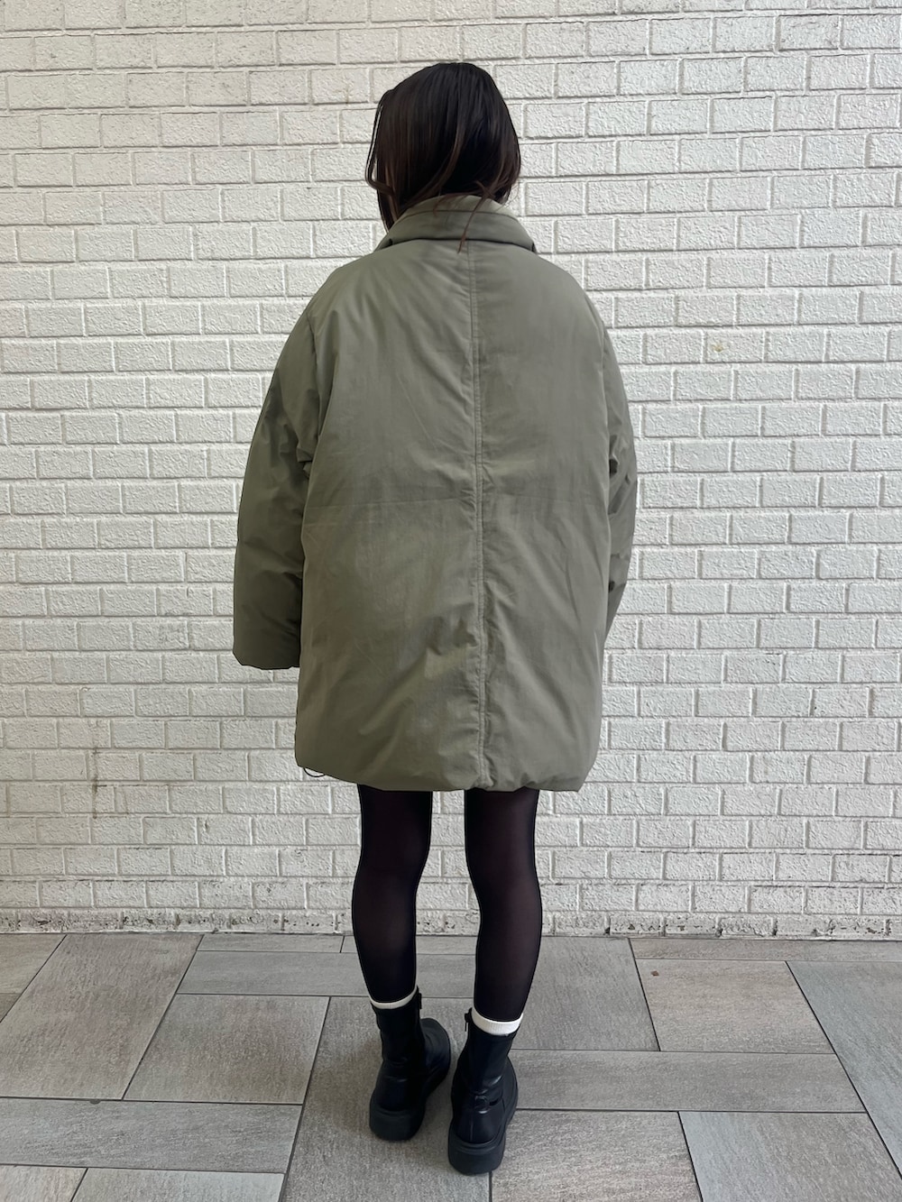 ベージュ系のダウンジャケット/コート、グレー系のスカートを着用したレディースの冬コーディネートの4枚目の写真