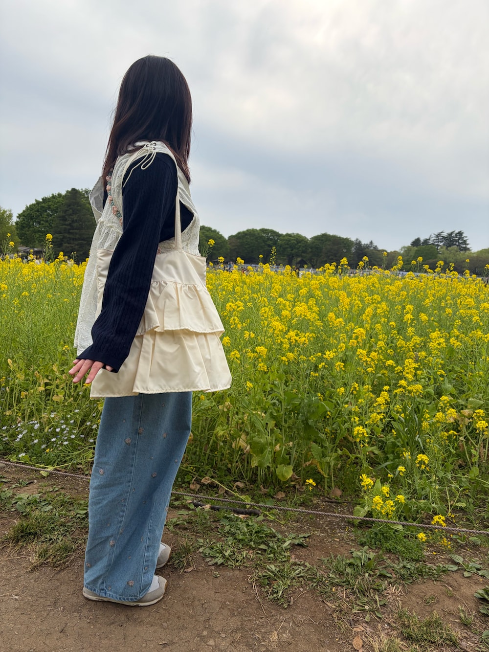 ホワイト系のベスト、ブラック系のニット/セーター、ブルー系のデニムパンツを着用したレディースの夏コーディネートの2枚目の写真