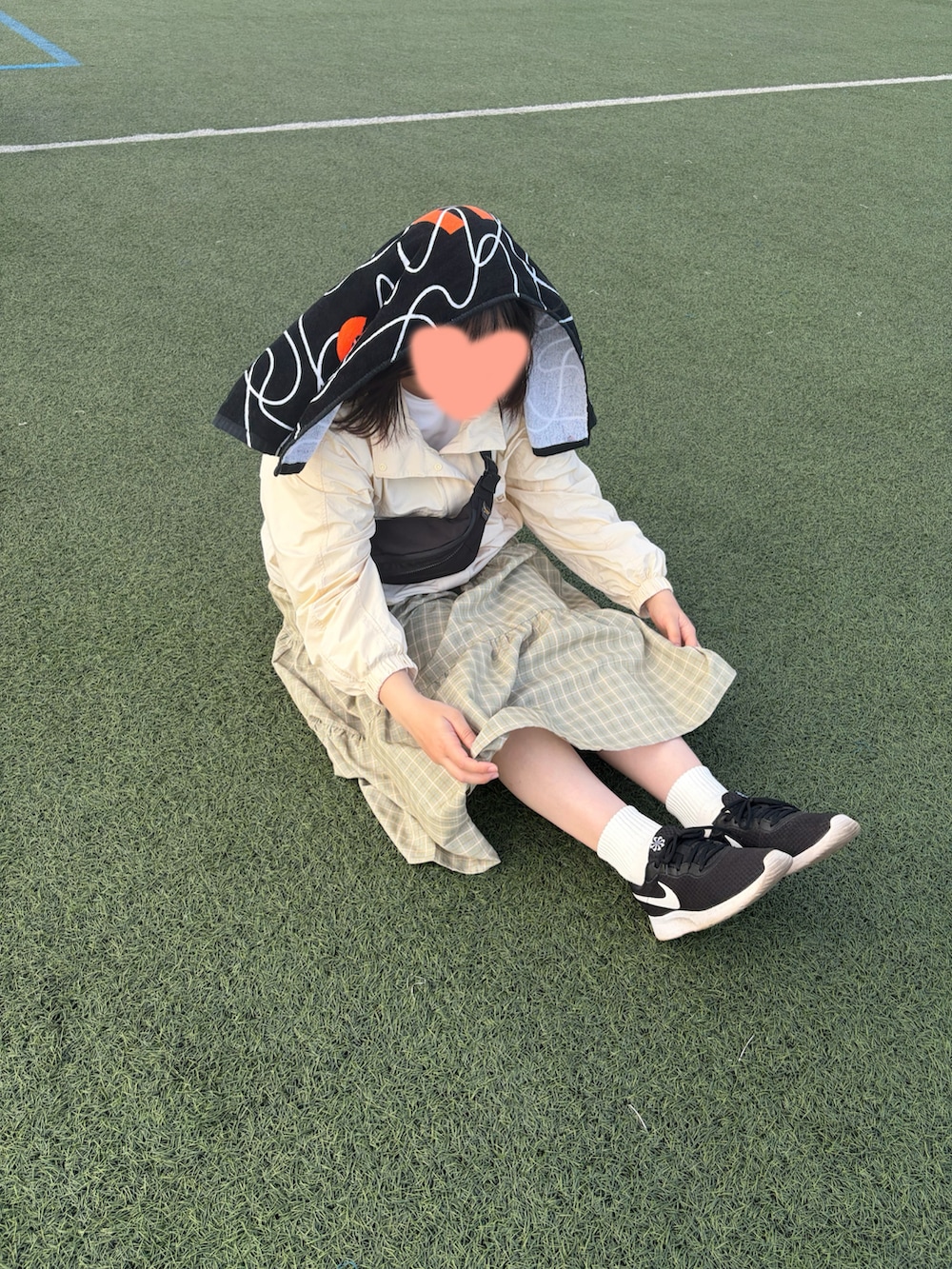 グリーン系のワンピース、ブラック系のスニーカー、イエロー系のナイロンジャケットを着用したレディースの夏コーディネートの2枚目の写真