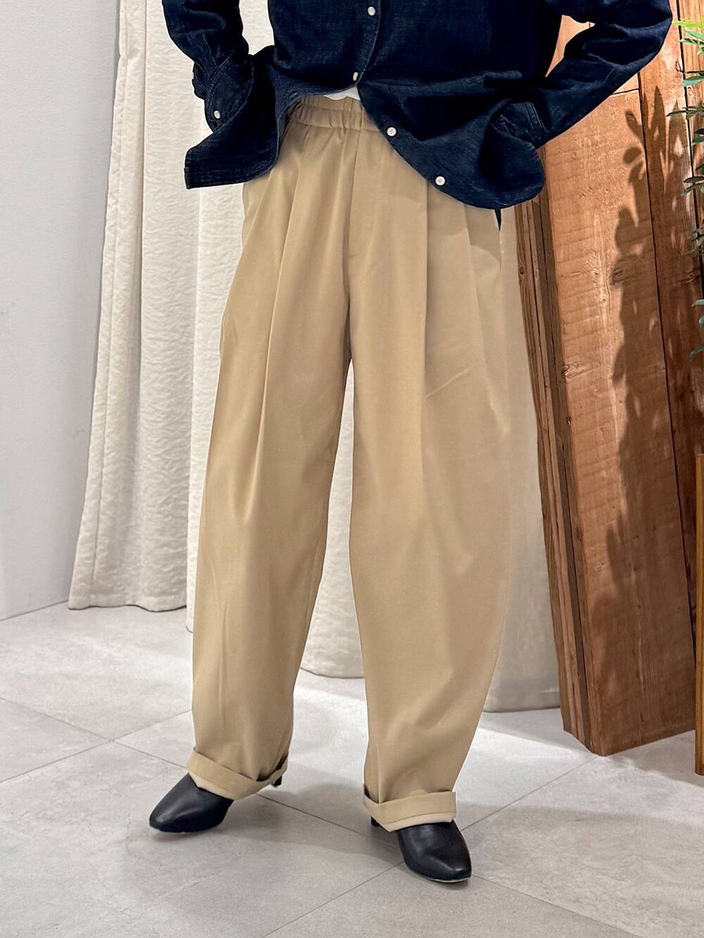 ブラック系のブーツ、ベージュ系のその他パンツ、ブラウン系のハンドバッグを着用したレディースの冬コーディネートの6枚目の写真