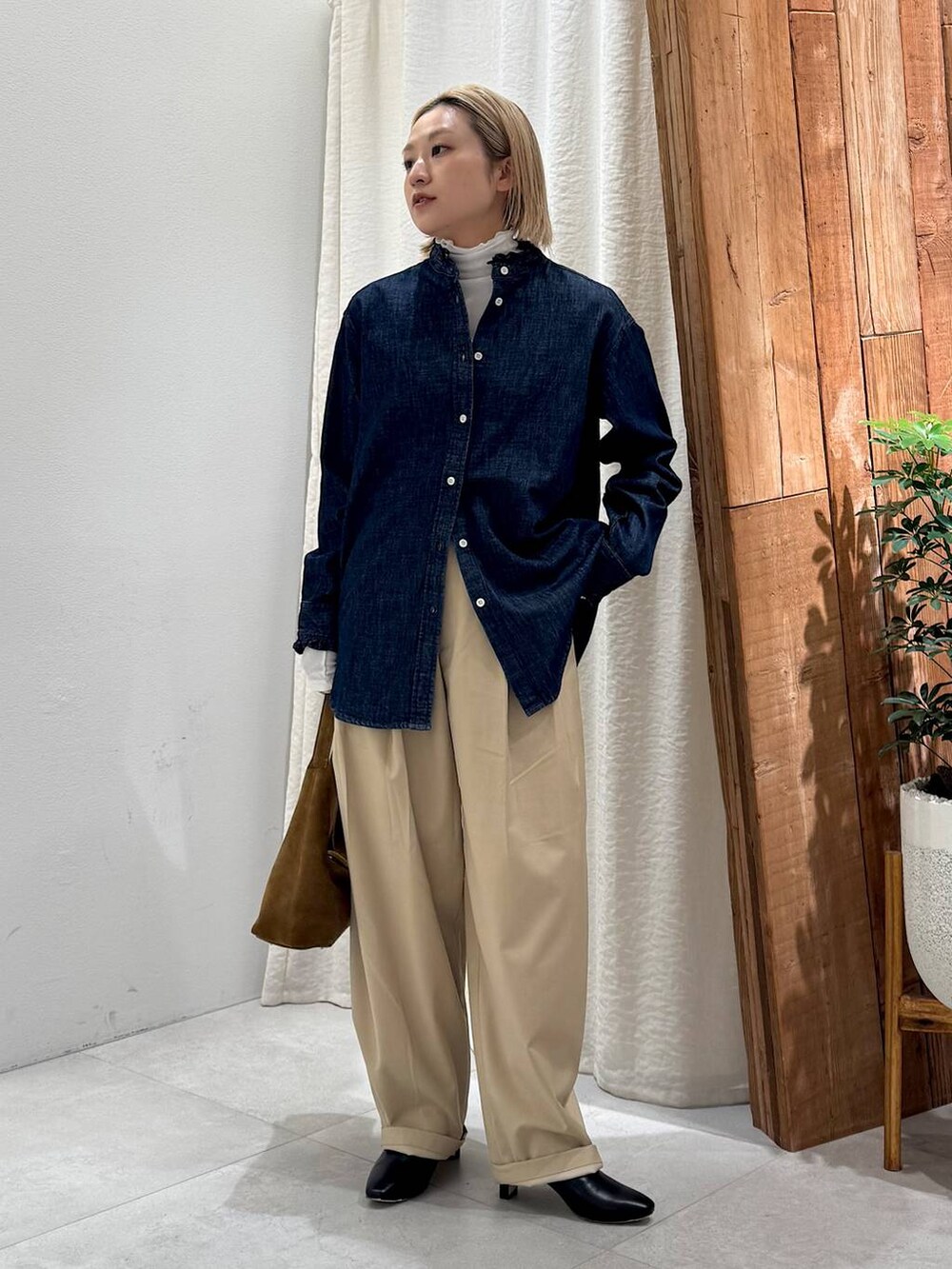 ブラック系のブーツ、ベージュ系のその他パンツ、ブラウン系のハンドバッグを着用したレディースの冬コーディネートの8枚目の写真