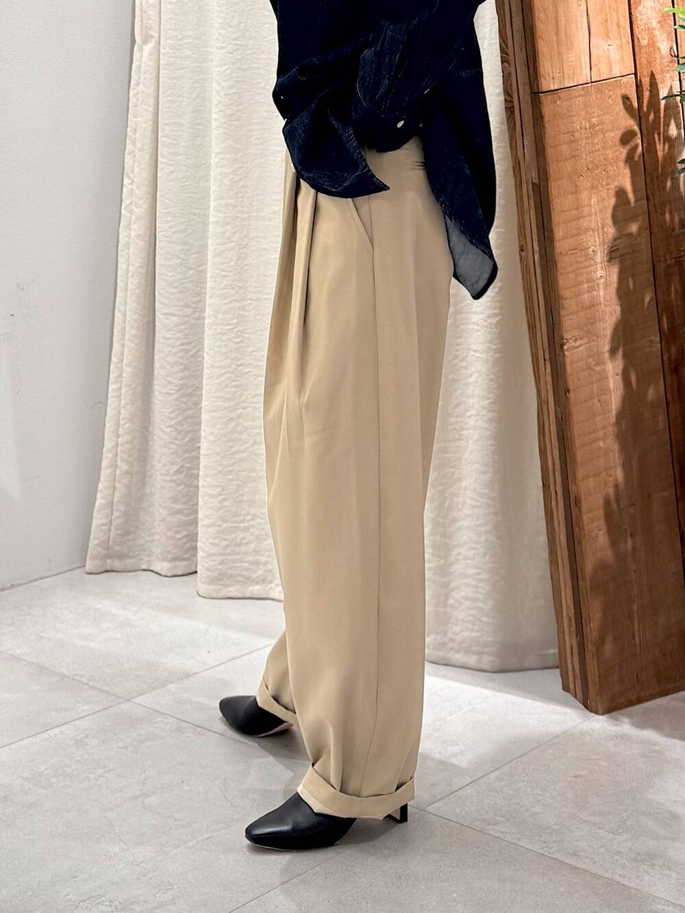 ブラック系のブーツ、ベージュ系のその他パンツ、ブラウン系のハンドバッグを着用したレディースの冬コーディネートの7枚目の写真