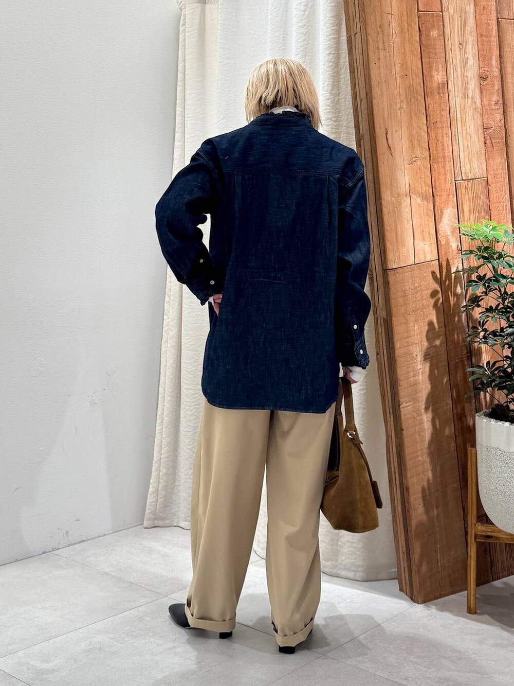 ブラック系のブーツ、ベージュ系のその他パンツ、ブラウン系のハンドバッグを着用したレディースの冬コーディネートの3枚目の写真