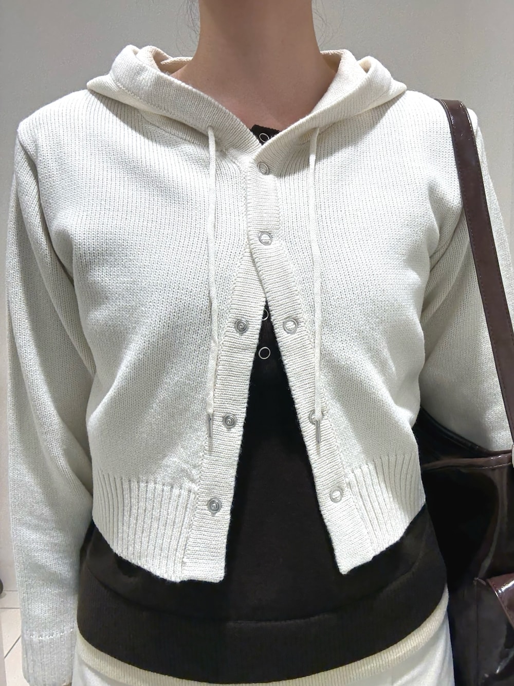 ホワイト系のニット/セーター、ブラウン系のニット/セーター、ベージュ系のスカートを着用したレディースの秋コーディネートの3枚目の写真