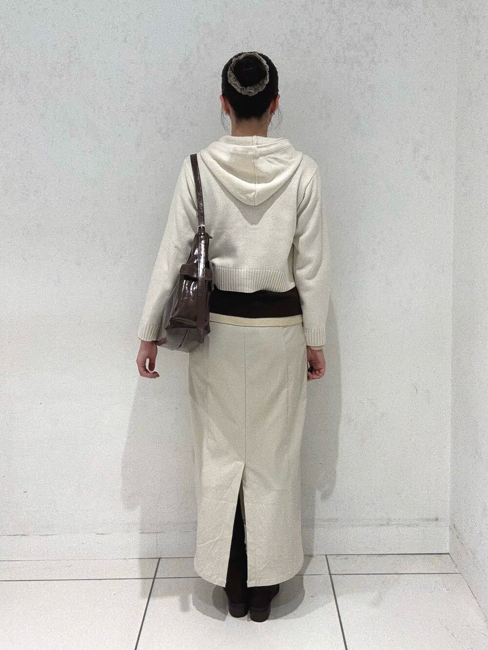 ホワイト系のニット/セーター、ブラウン系のニット/セーター、ベージュ系のスカートを着用したレディースの秋コーディネートの2枚目の写真