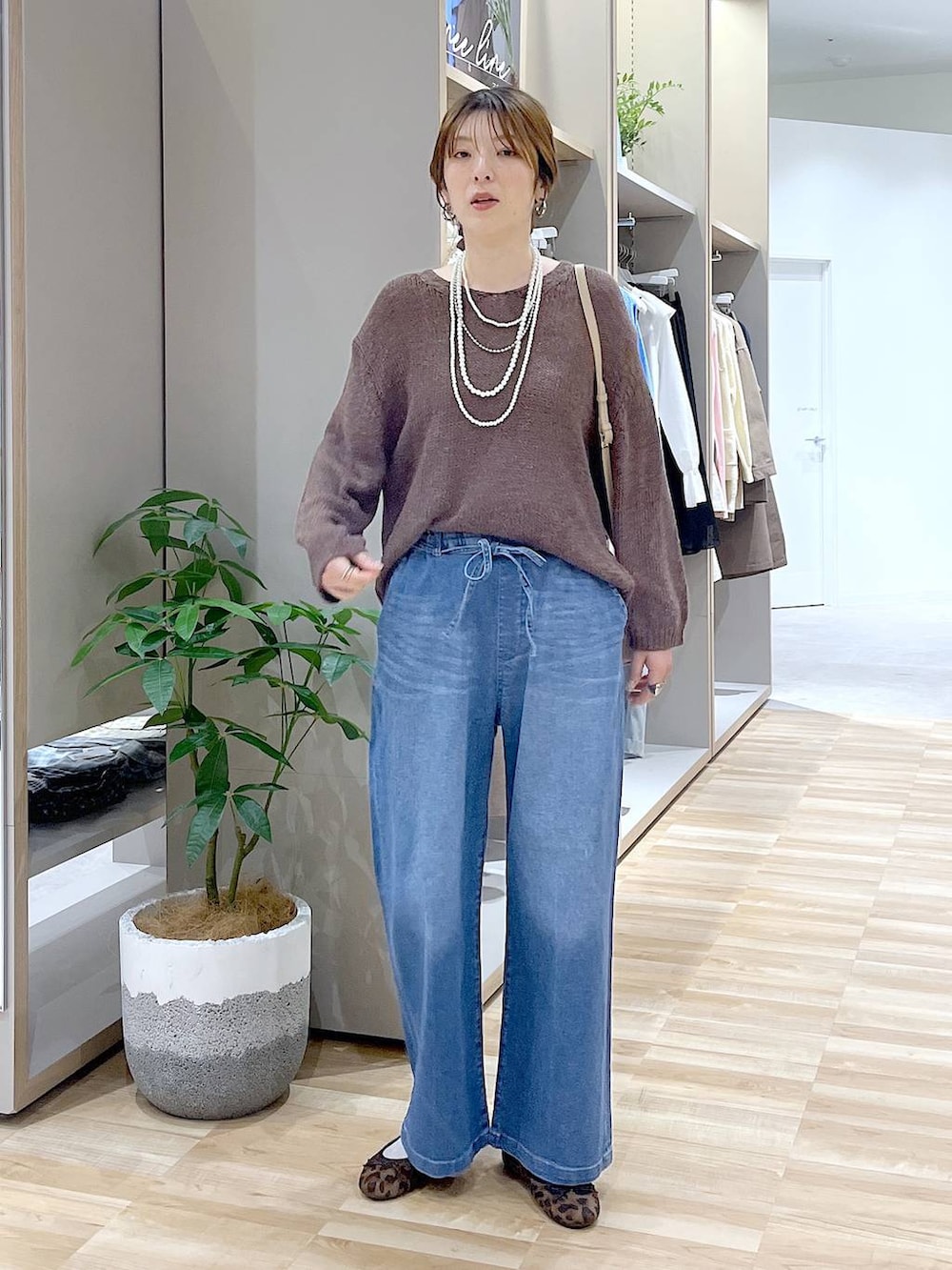 その他のバレエシューズ、ブルー系のデニムパンツ、ベージュ系のショルダーバッグを着用したレディースの春コーディネートの4枚目の写真