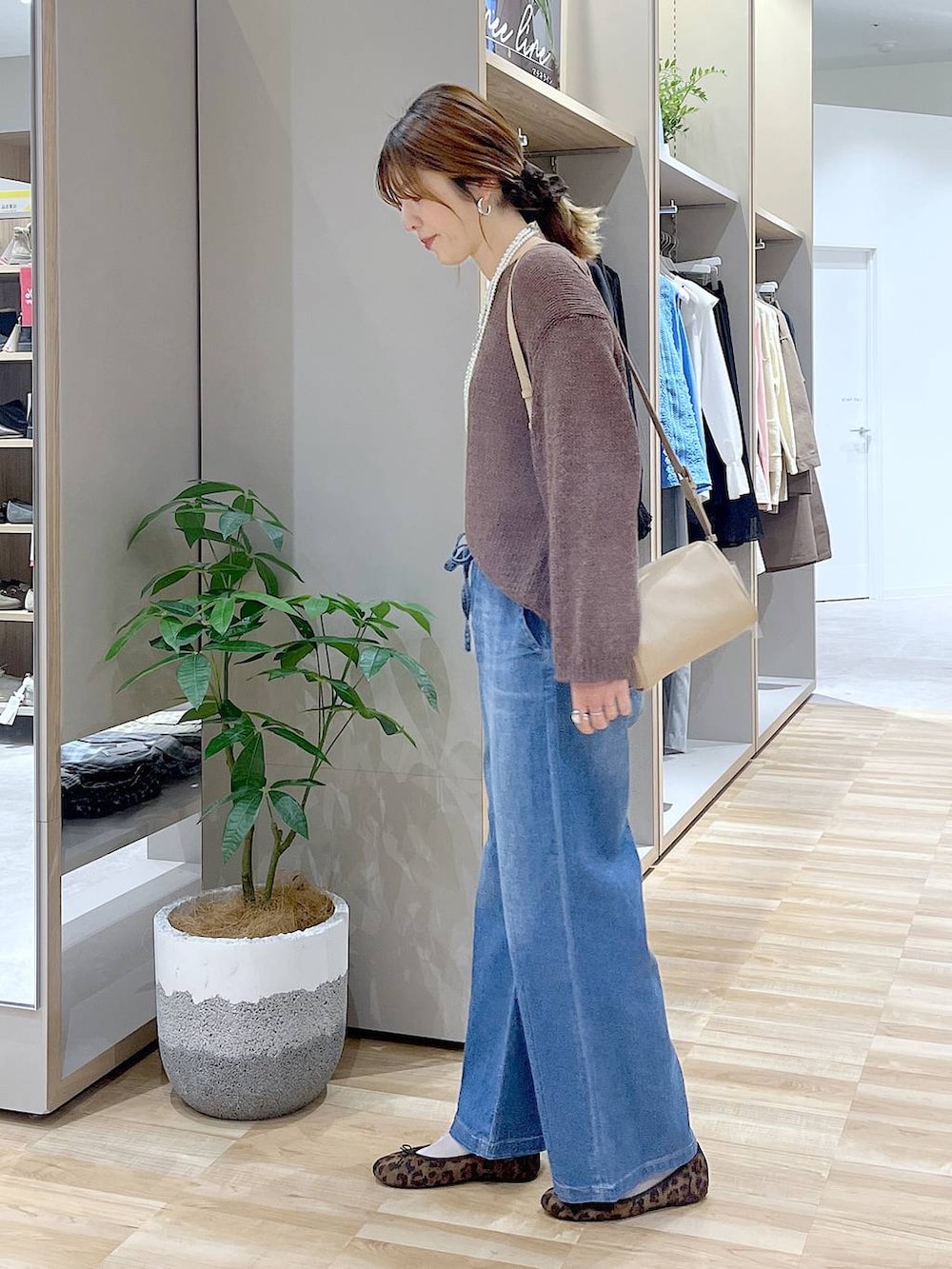 その他のバレエシューズ、ブルー系のデニムパンツ、ベージュ系のショルダーバッグを着用したレディースの春コーディネートの2枚目の写真