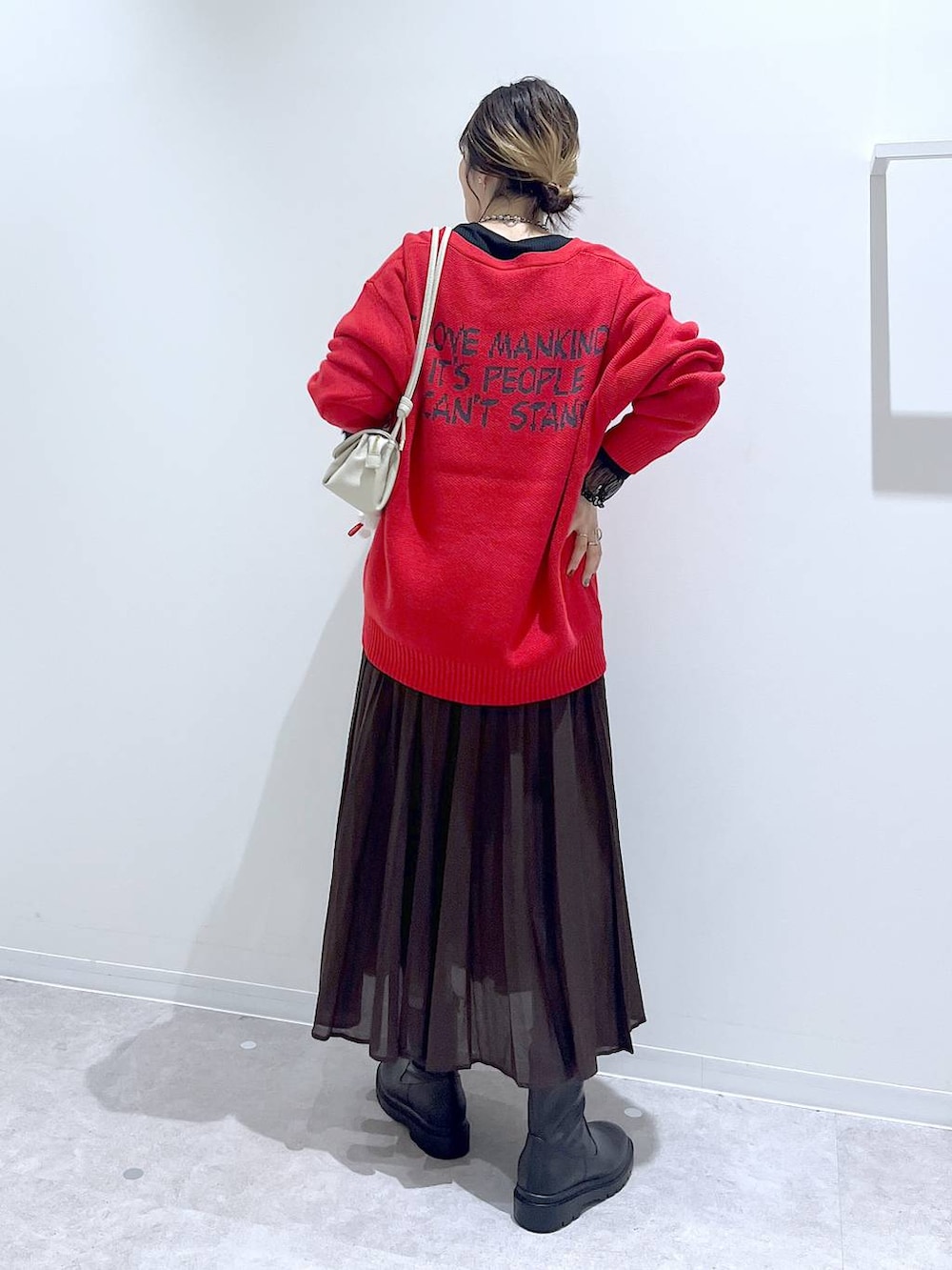 ブラウン系のスカート、ベージュ系のショルダーバッグ、ブラック系のTシャツ/カットソーを着用したレディースの秋コーディネートの3枚目の写真