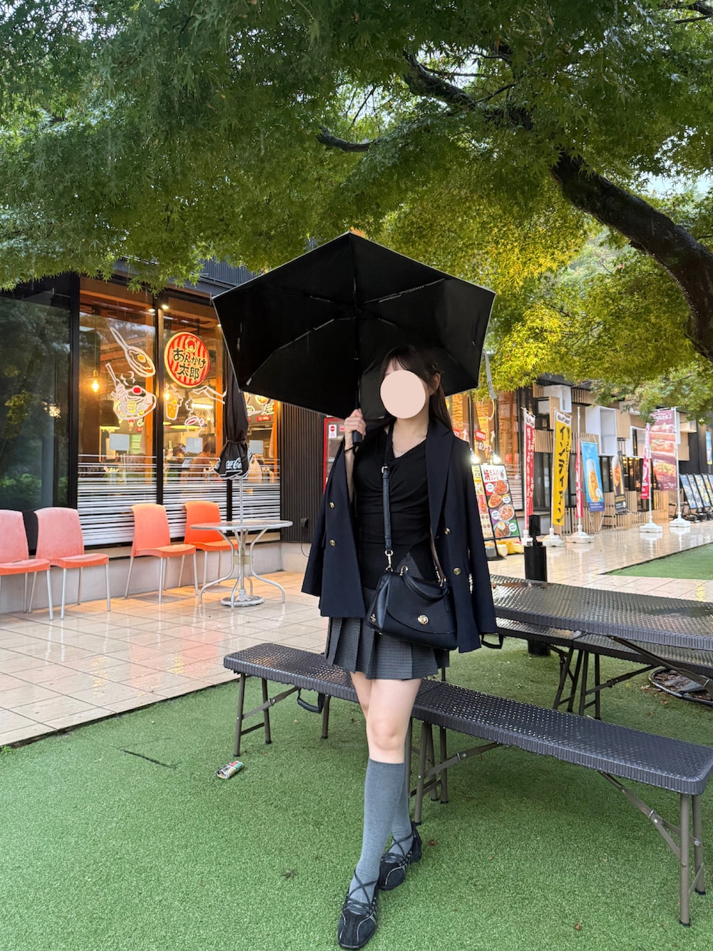 ブラック系のスニーカー、グレー系のスカート、ブルー系のテーラードジャケットを着用したレディースの秋コーディネートの2枚目の写真