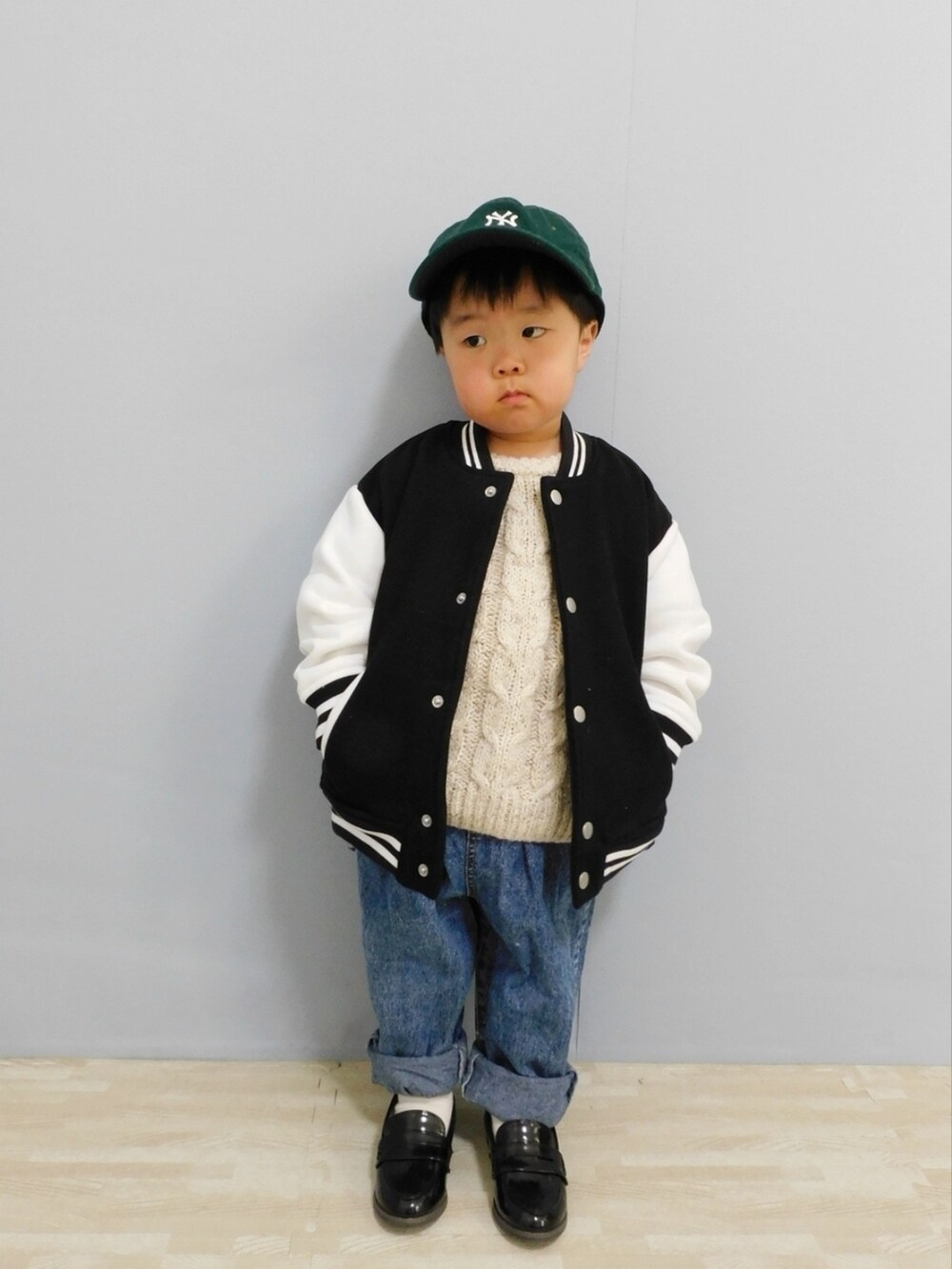 ブラック系のスタジャン、ブルー系のデニムパンツ、ブラック系のローファーを着用したキッズの冬コーディネートの4枚目の写真