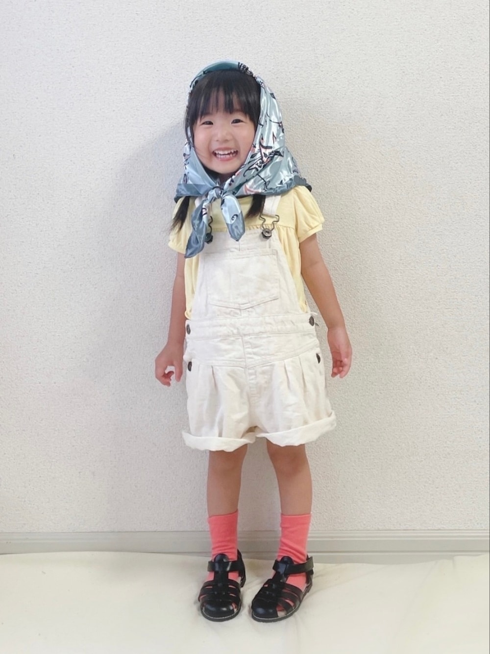 イエロー系のTシャツ/カットソー、ホワイト系のサロペット/オーバーオール、ブラック系のサンダルを着用したキッズの秋コーディネートの3枚目の写真