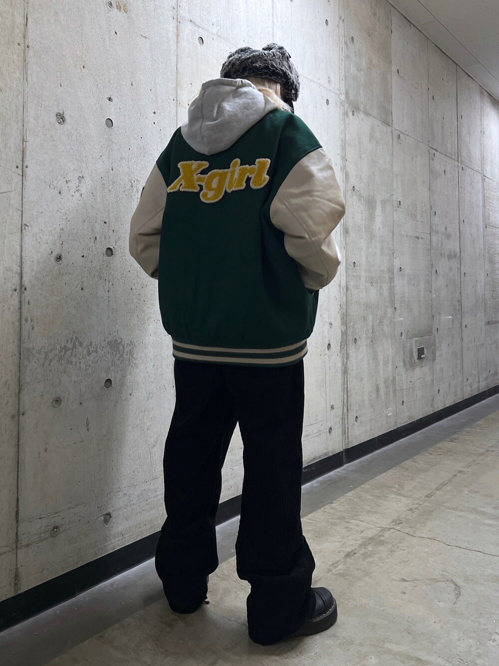 グレー系のパーカー、グリーン系のスタジャン、ブラック系のその他パンツを着用したレディースの秋コーディネートの2枚目の写真