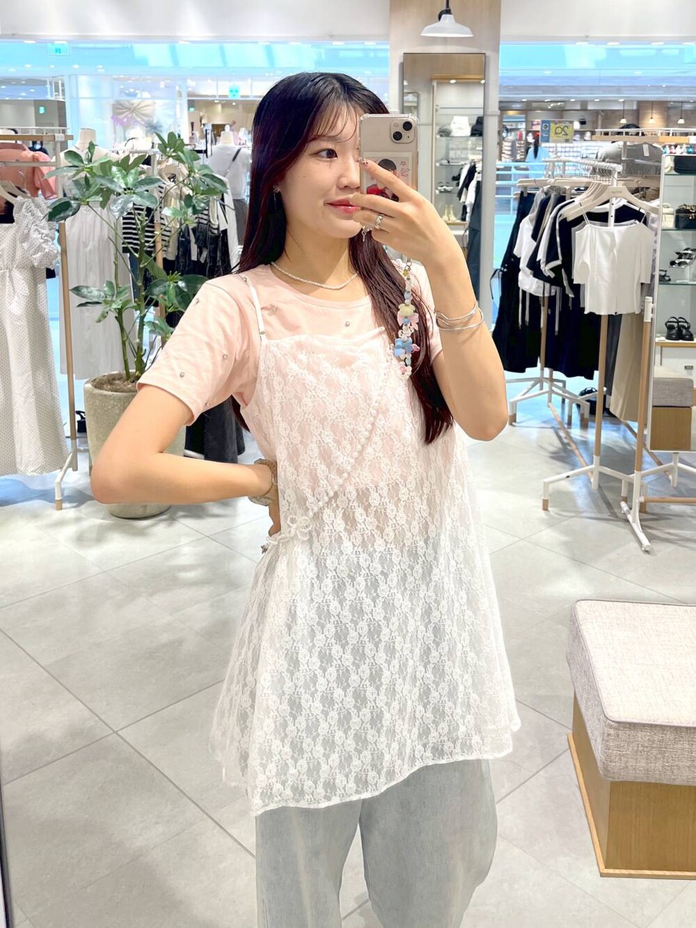 シルバー系のサンダル、ホワイト系のキャミソール、ブルー系のデニムパンツを着用したレディースの春コーディネートの3枚目の写真