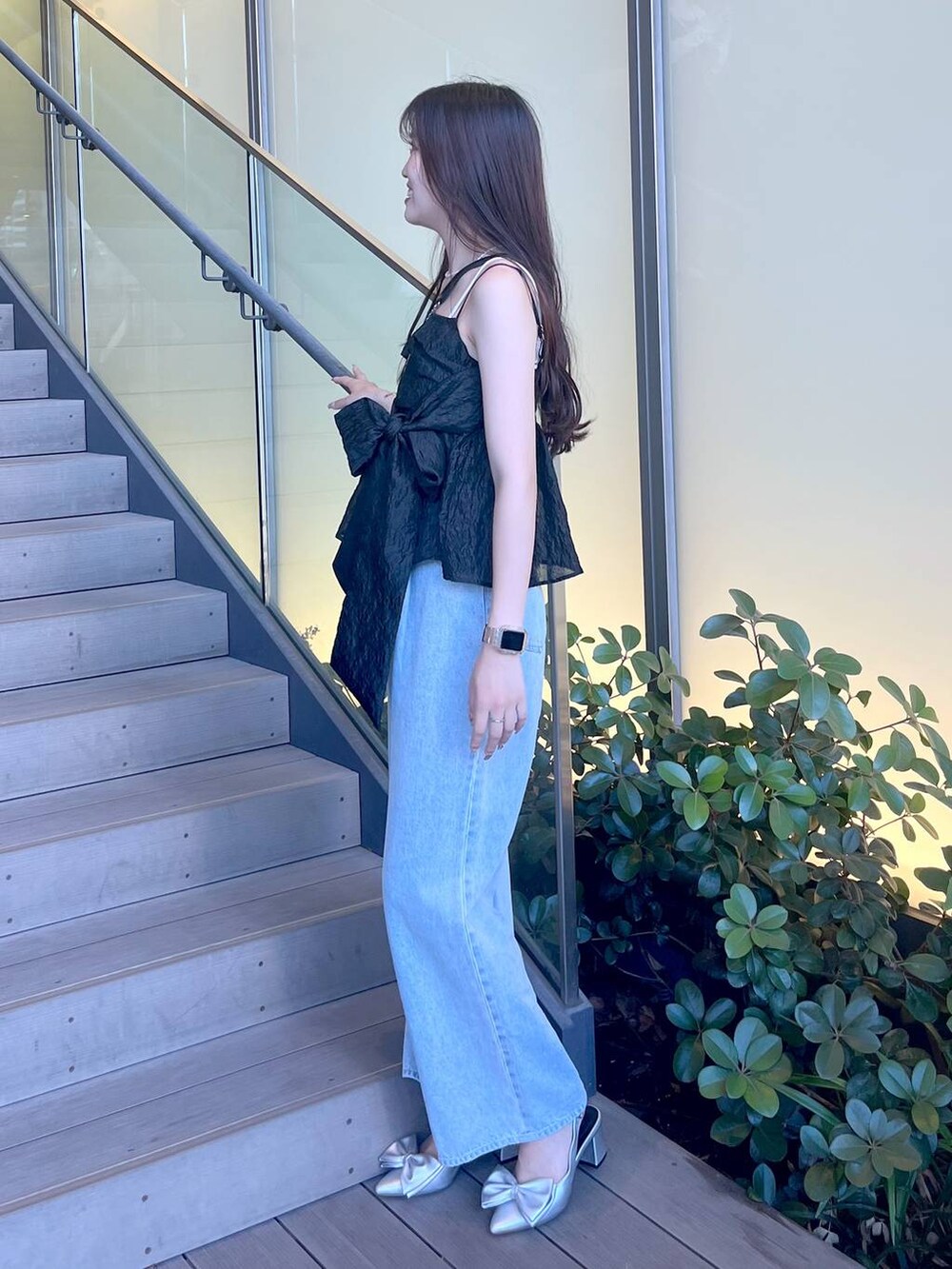 シルバー系のサンダル、ブラック系のショルダーバッグ、ホワイト系のキャミソールを着用したレディースの夏コーディネートの3枚目の写真