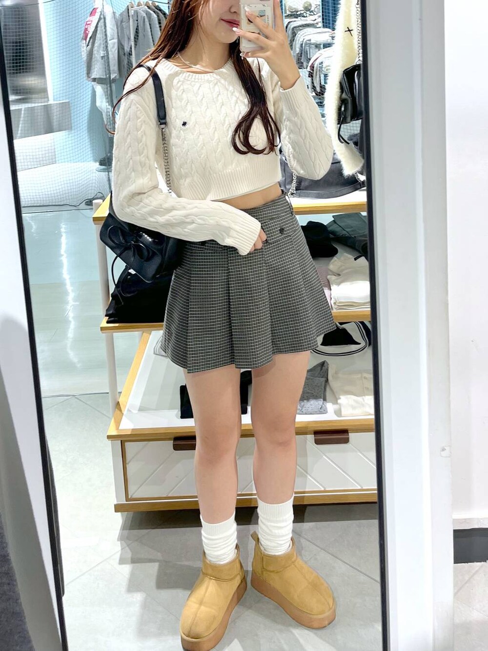 ホワイト系のニット/セーター、ブラック系のショルダーバッグ、ベージュ系のスカートを着用したレディースの秋コーディネートの4枚目の写真