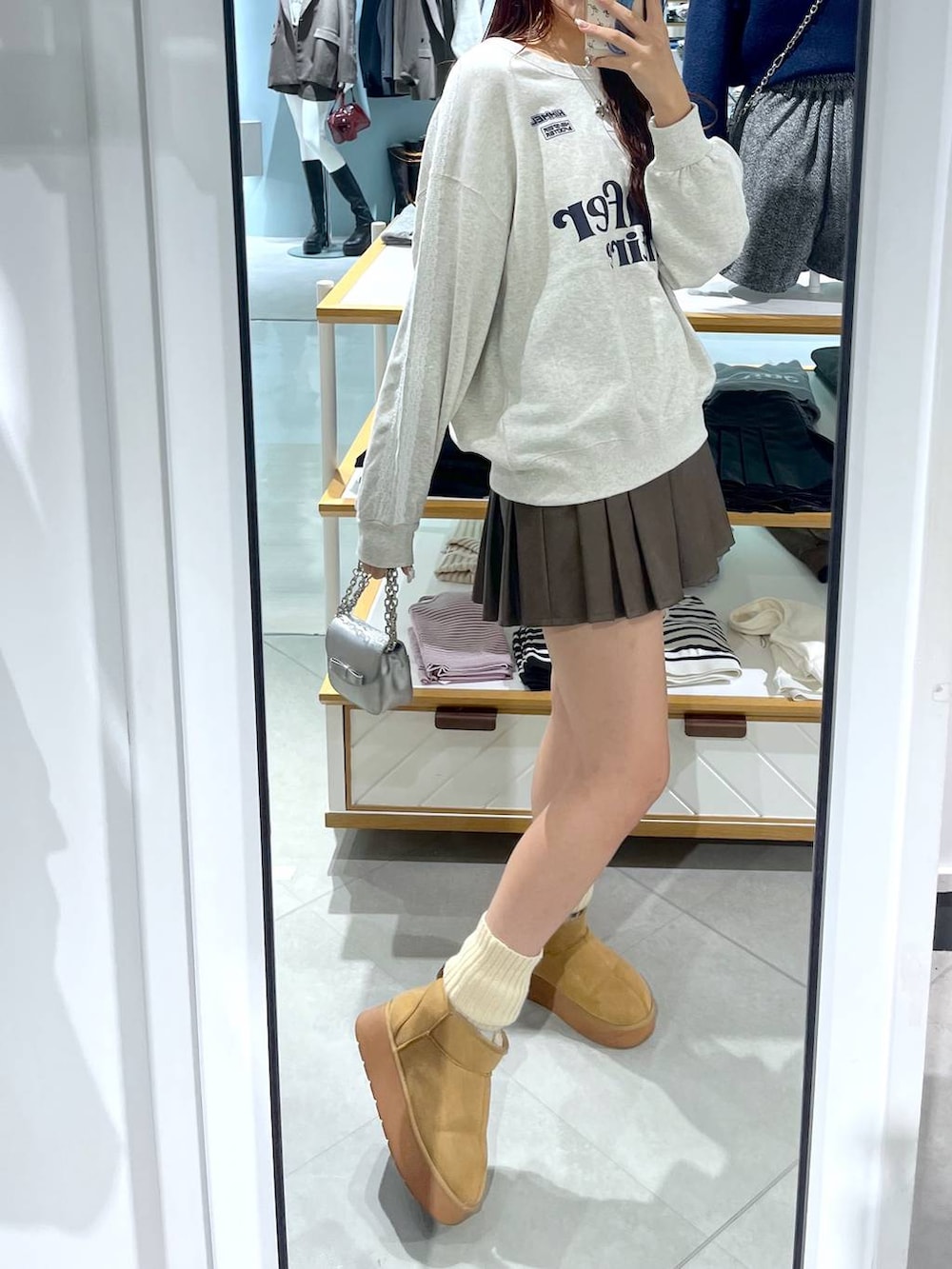 ホワイト系のTシャツ/カットソー、ブラウン系のスカート、ベージュ系のブーツを着用したレディースの秋コーディネートの8枚目の写真