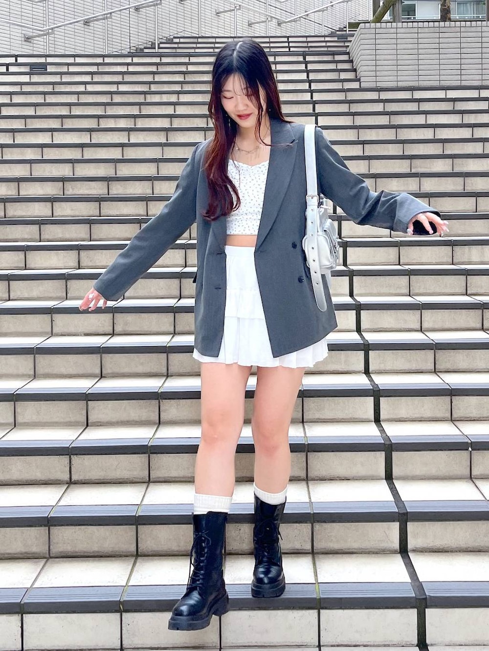 ホワイト系のキャミソール、ホワイト系のスカート、グレー系のテーラードジャケットを着用したレディースの春コーディネートの5枚目の写真