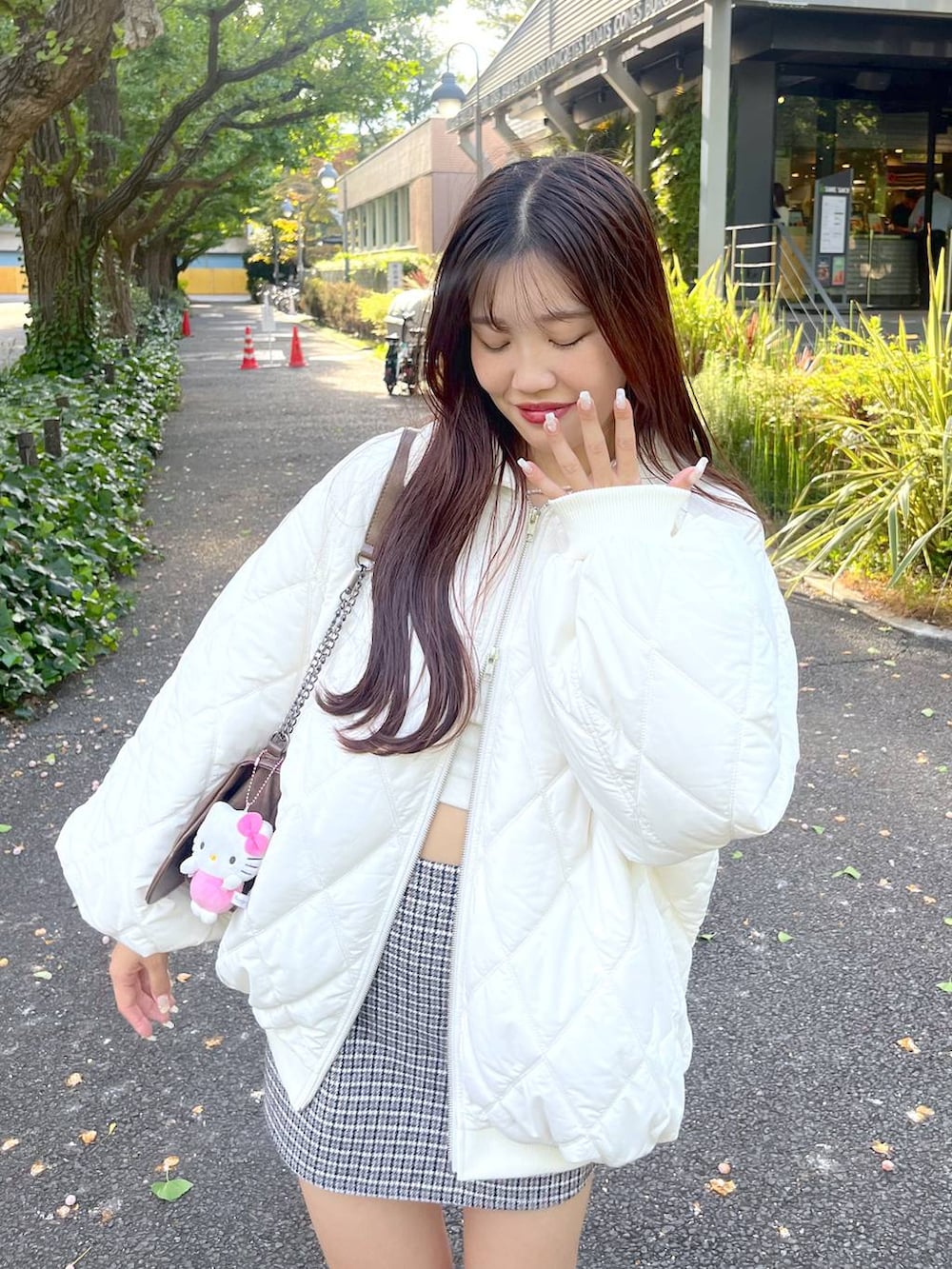 ブラウン系のショルダーバッグ、ホワイト系のTシャツ/カットソー、ベージュ系のブーツを着用したレディースの秋コーディネートの5枚目の写真