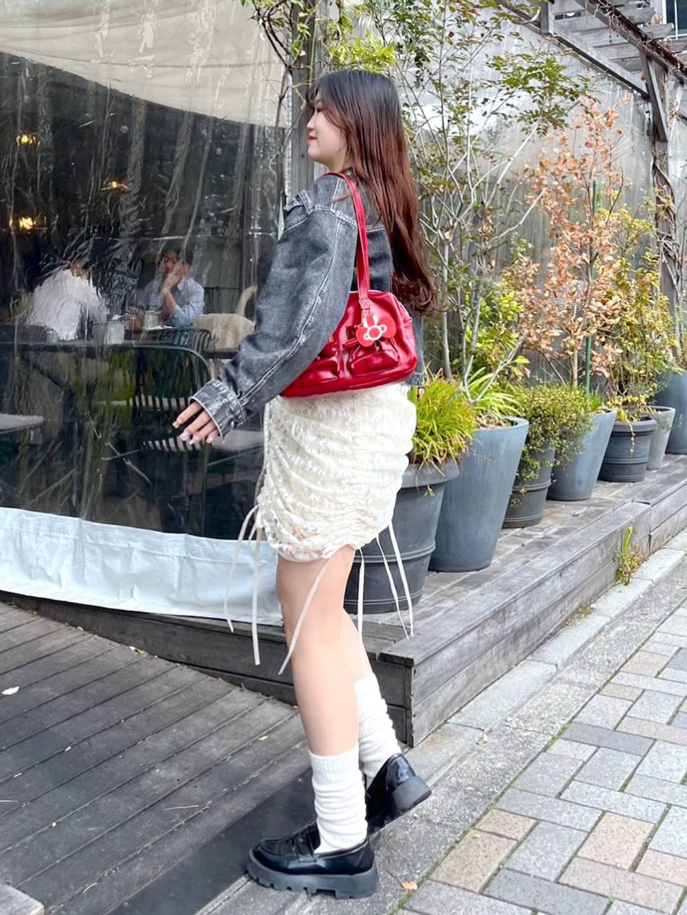 ホワイト系のキャミソール、ベージュ系のワンピース、ブラック系のローファーを着用したレディースの春コーディネートの3枚目の写真