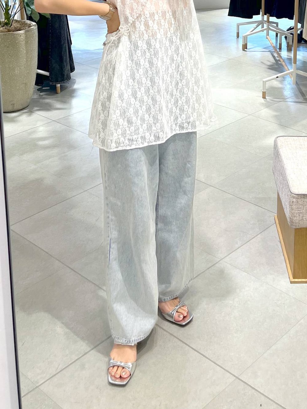 シルバー系のサンダル、ホワイト系のキャミソール、ブルー系のデニムパンツを着用したレディースの春コーディネートの5枚目の写真