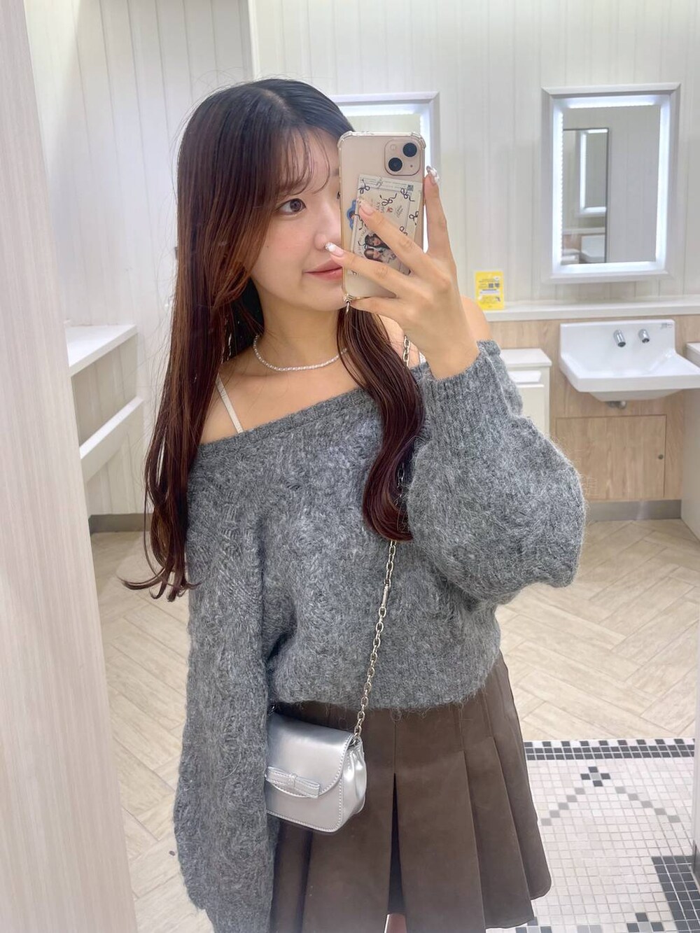 ブラウン系のスカート、ホワイト系のキャミソール、シルバー系のショルダーバッグを着用したレディースの秋コーディネートの7枚目の写真