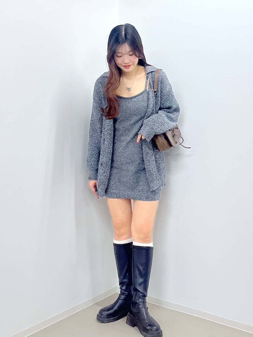 ブラウン系のショルダーバッグ、ホワイト系のキャミソール、ブラック系のブーツを着用したレディースの春コーディネートの7枚目の写真