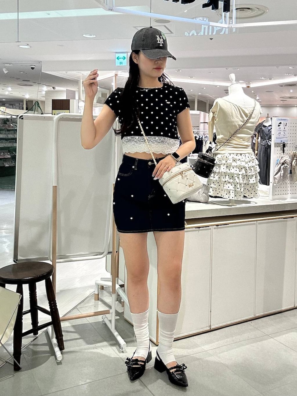 ホワイト系のショルダーバッグ、ブラック系のパンプス、ホワイト系のチューブトップを着用したレディースの夏コーディネートの2枚目の写真