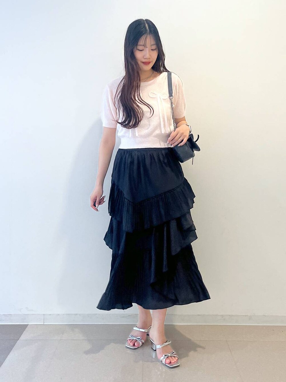 グレー系のショルダーバッグ、ホワイト系のキャミソール、ブラック系のスカートを着用したレディースの春コーディネートの10枚目の写真