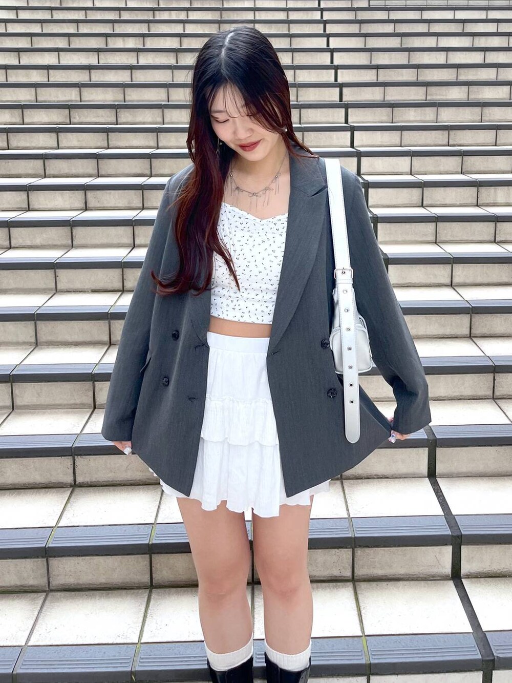 ホワイト系のキャミソール、ホワイト系のスカート、グレー系のテーラードジャケットを着用したレディースの春コーディネートの3枚目の写真