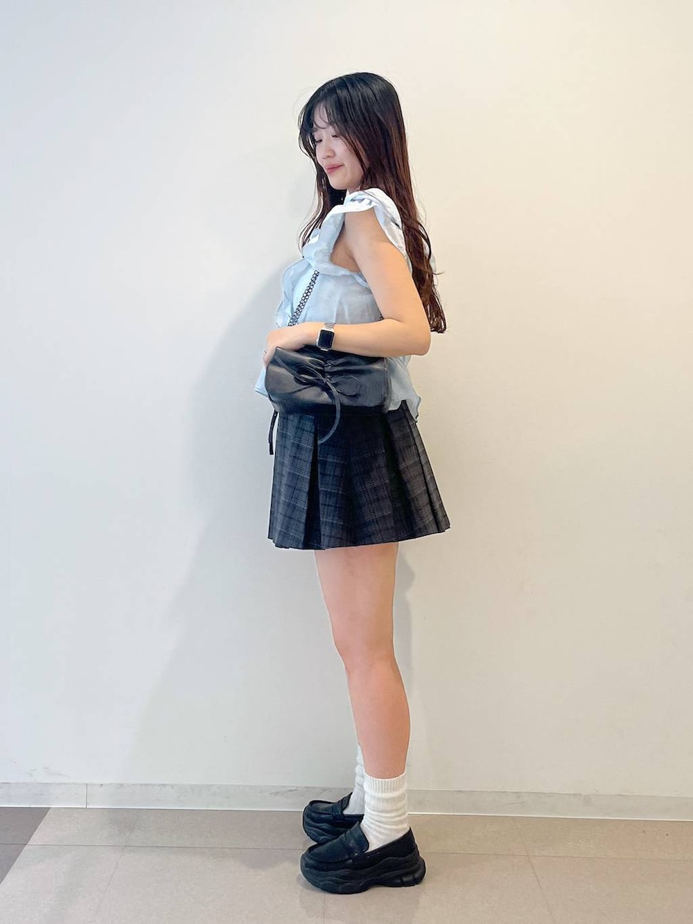 グレー系のショルダーバッグ、ホワイト系のキャミソール、ブラック系のローファーを着用したレディースの夏コーディネートの3枚目の写真