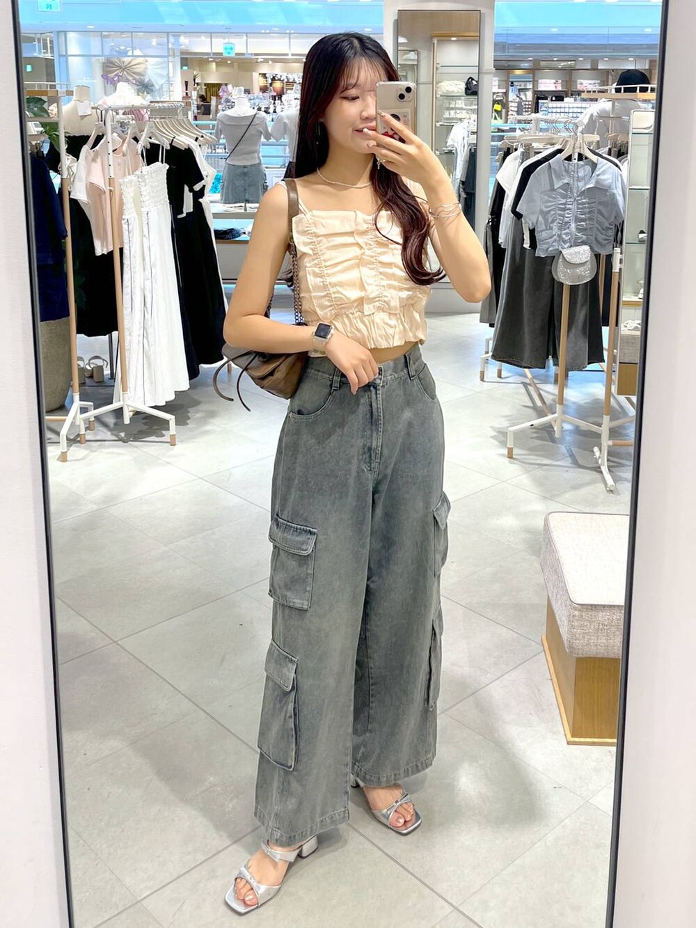 シルバー系のサンダル、ホワイト系のキャミソール、ブルー系のデニムパンツを着用したレディースの夏コーディネートの7枚目の写真