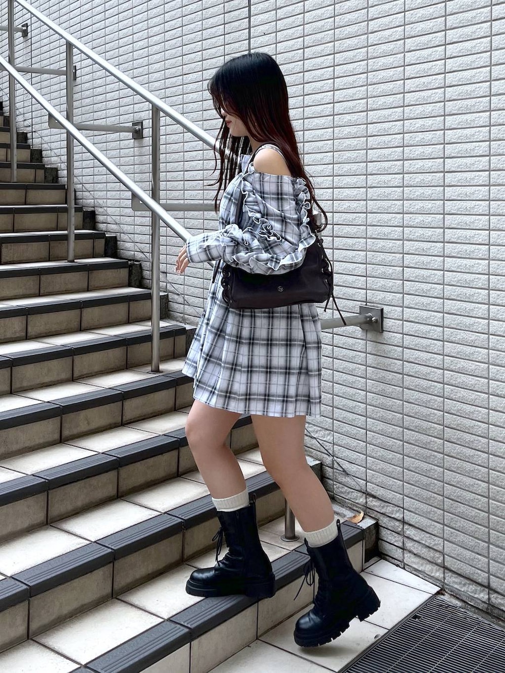 ホワイト系のキャミソール、ブラック系のデニムスカート、ブラウン系のショルダーバッグを着用したレディースの春コーディネートの5枚目の写真