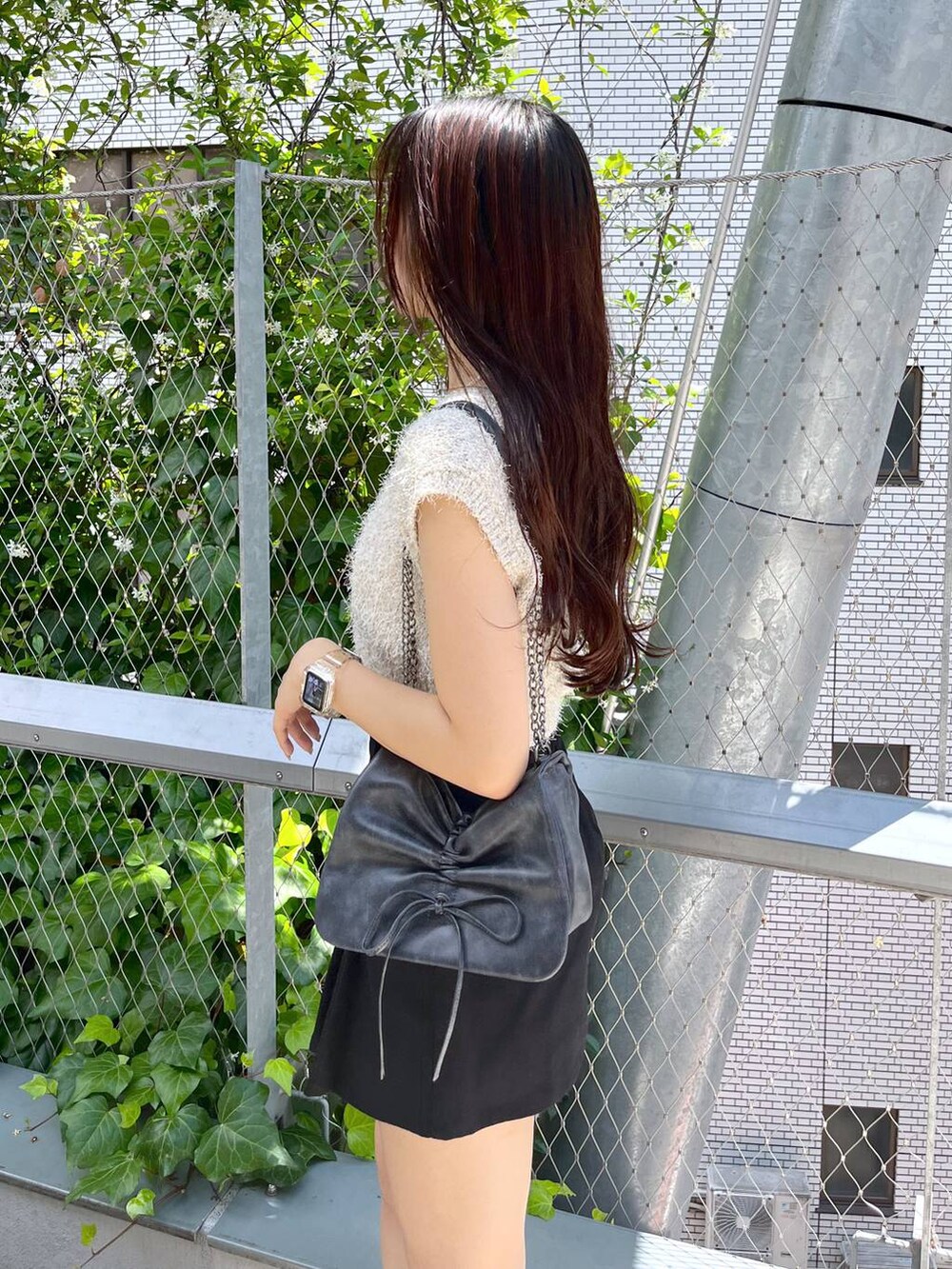 ブラック系のスカート、ホワイト系のキャミソール、ホワイト系のサンダルを着用したレディースの夏コーディネートの5枚目の写真