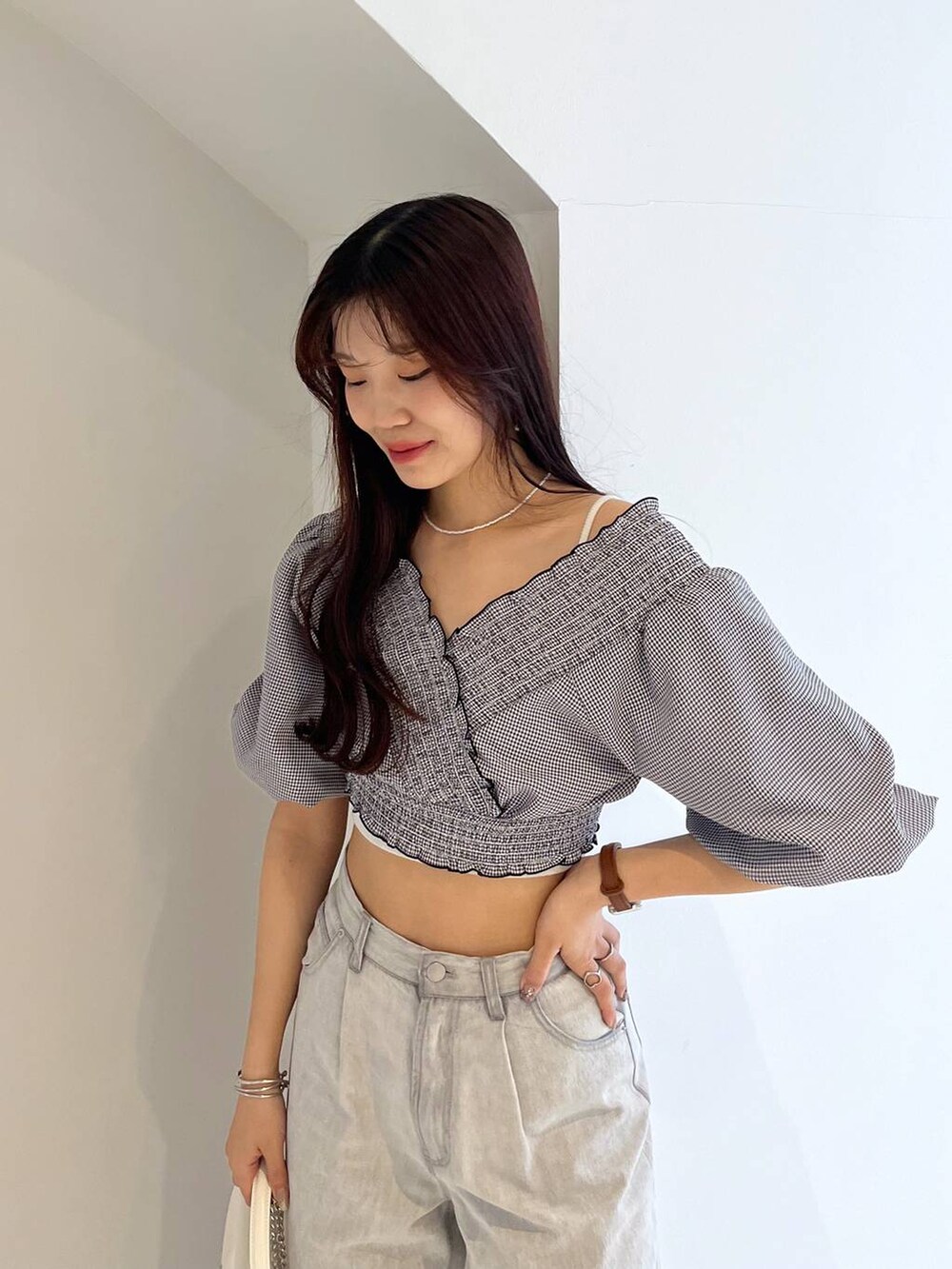 シルバー系のサンダル、ホワイト系のキャミソール、グレー系のデニムパンツを着用したレディースの春コーディネートの5枚目の写真