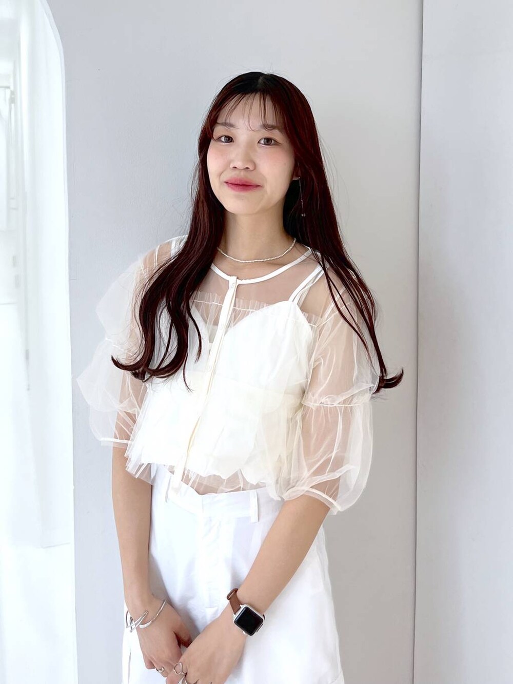 シルバー系のショルダーバッグ、ホワイト系のキャミソール、ホワイト系のベストを着用したレディースの夏コーディネートの7枚目の写真