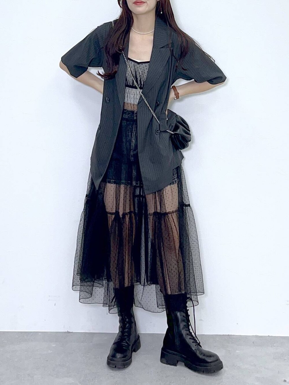 ブラック系のショルダーバッグ、ホワイト系のキャミソール、ブラック系のブーツを着用したレディースの夏コーディネートの7枚目の写真