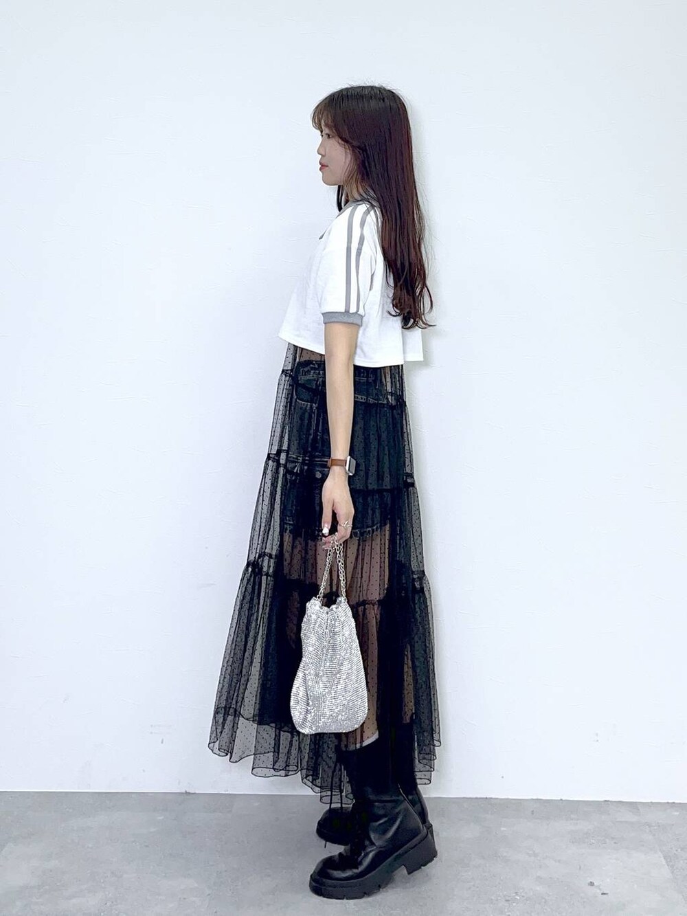 ブラック系のワンピース、ブラック系のブーツ、ブラック系のデニムスカートを着用したレディースの春コーディネートの2枚目の写真