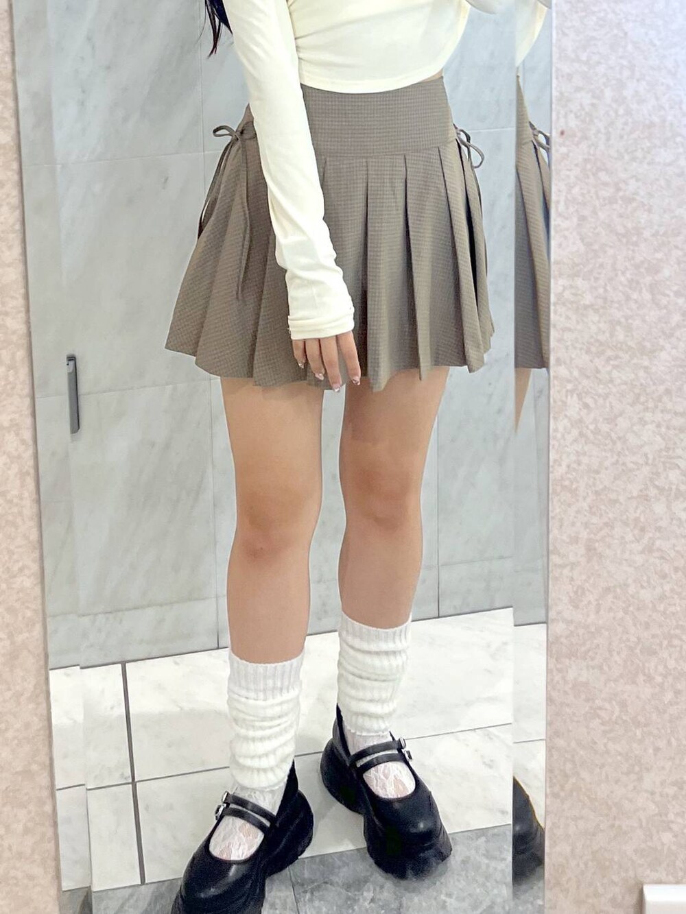 ブラック系のスニーカー、ホワイト系のキャミソール、ブラウン系のスカートを着用したレディースの夏コーディネートの8枚目の写真