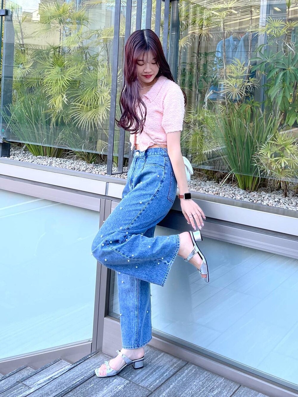 ホワイト系のショルダーバッグ、ホワイト系のキャミソール、ブルー系のデニムパンツを着用したレディースの春コーディネートの2枚目の写真