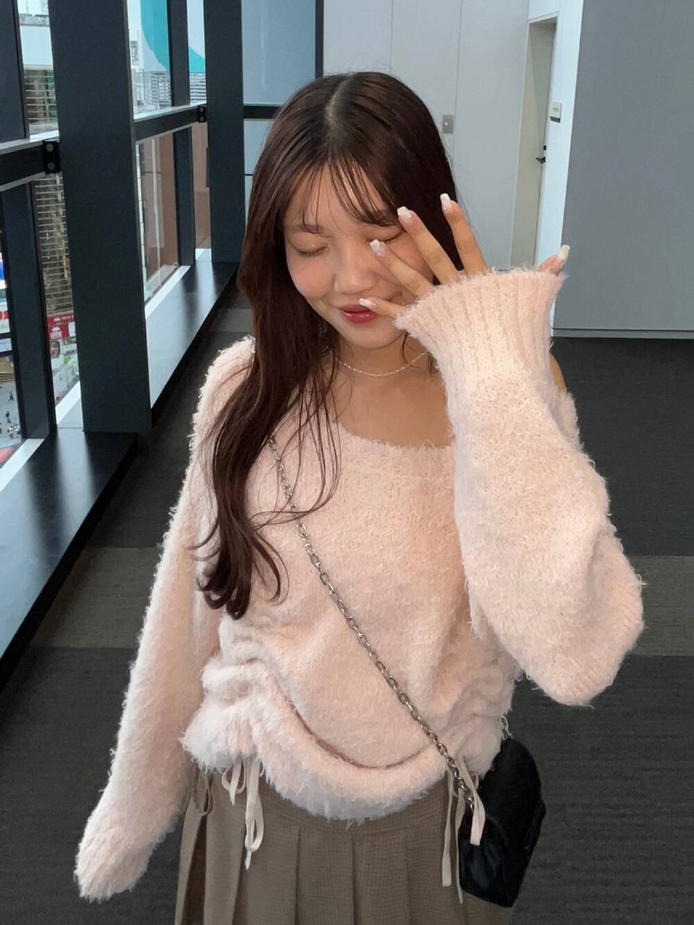 ブラウン系のスカート、ホワイト系のキャミソール、ブラック系のショルダーバッグを着用したレディースの冬コーディネートの2枚目の写真