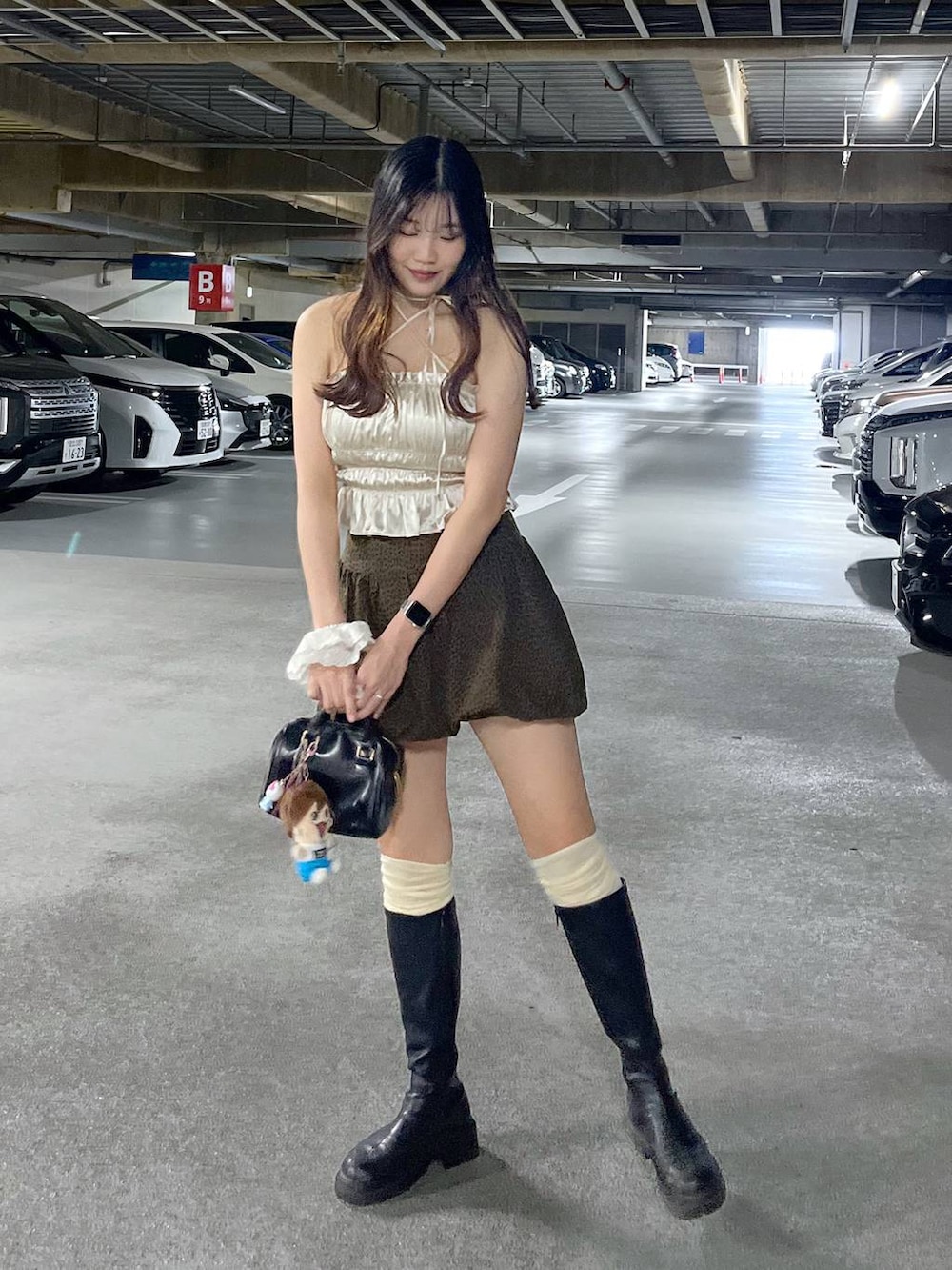 ブラック系のブーツ、ホワイト系のキャミソール、ブラウン系のスカートを着用したレディースの夏コーディネートの7枚目の写真