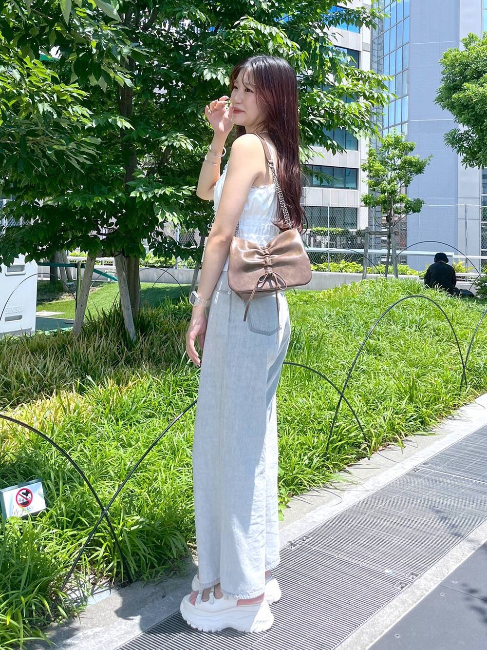 ホワイト系のキャミソール、グレー系のデニムパンツ、ホワイト系のサンダルを着用したレディースの夏コーディネートの6枚目の写真